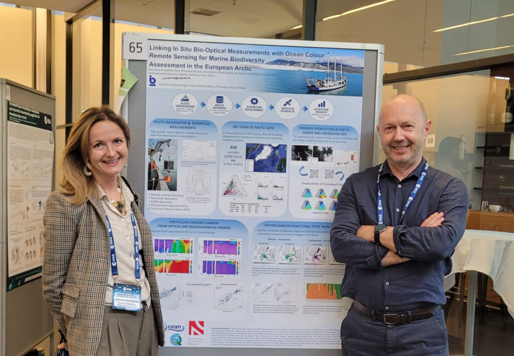 Katarzyna Dragańska-Deja and Mirosław Darecki standing in front of the poster